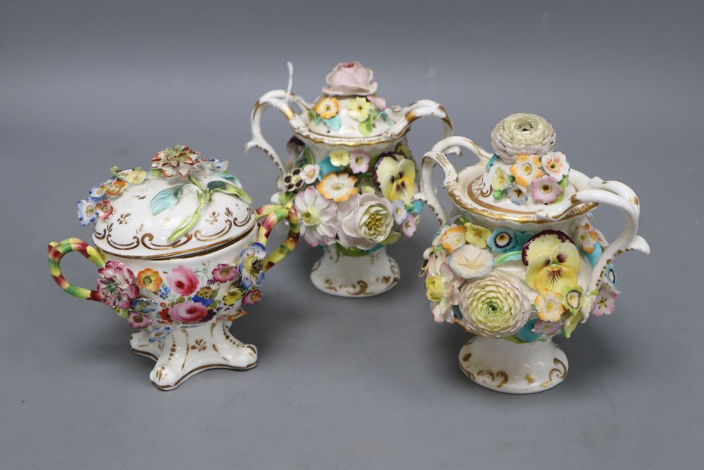 A pair of Minton or Coalport two handled floral encrusted pot pourri vases and covers and a floral encrusted vase and cover (3)